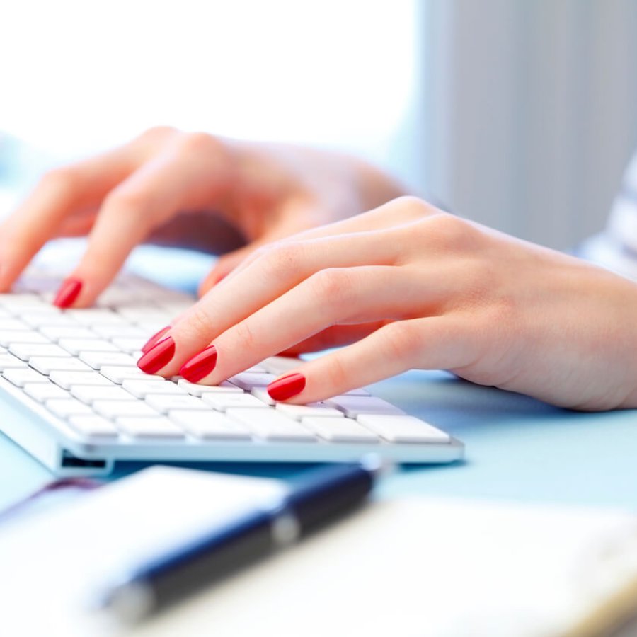 Working online Close-up of woman's hands are typing on a computer keyboard. Young businesswoman sitting at office and working online.